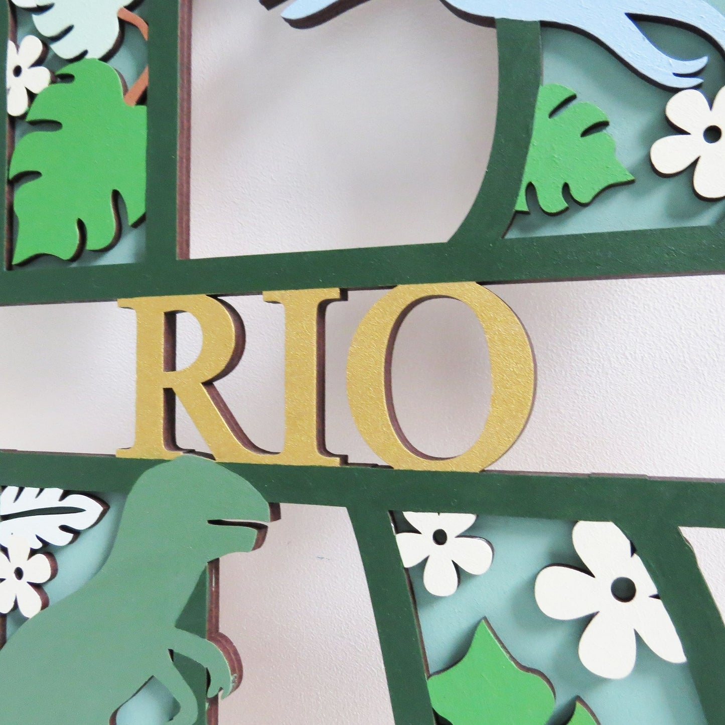 Personalised kids dinosaur themed letter painted in shades of green.