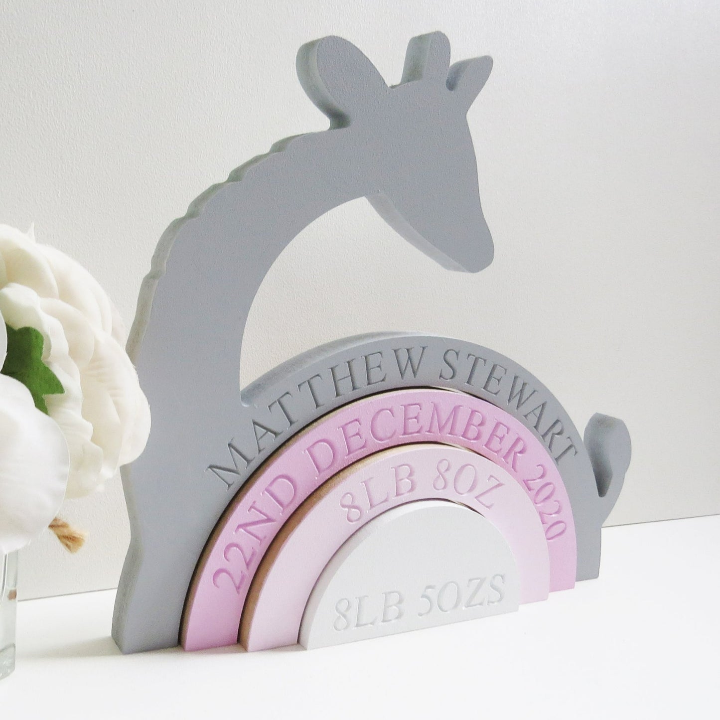 a childrens fully engraved Giraffe Rainbow Shelfie Stacker painted grey and shades of pink. perfect for any nursery, bedroom or playroom.