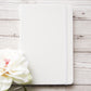 White leather bound notebook.