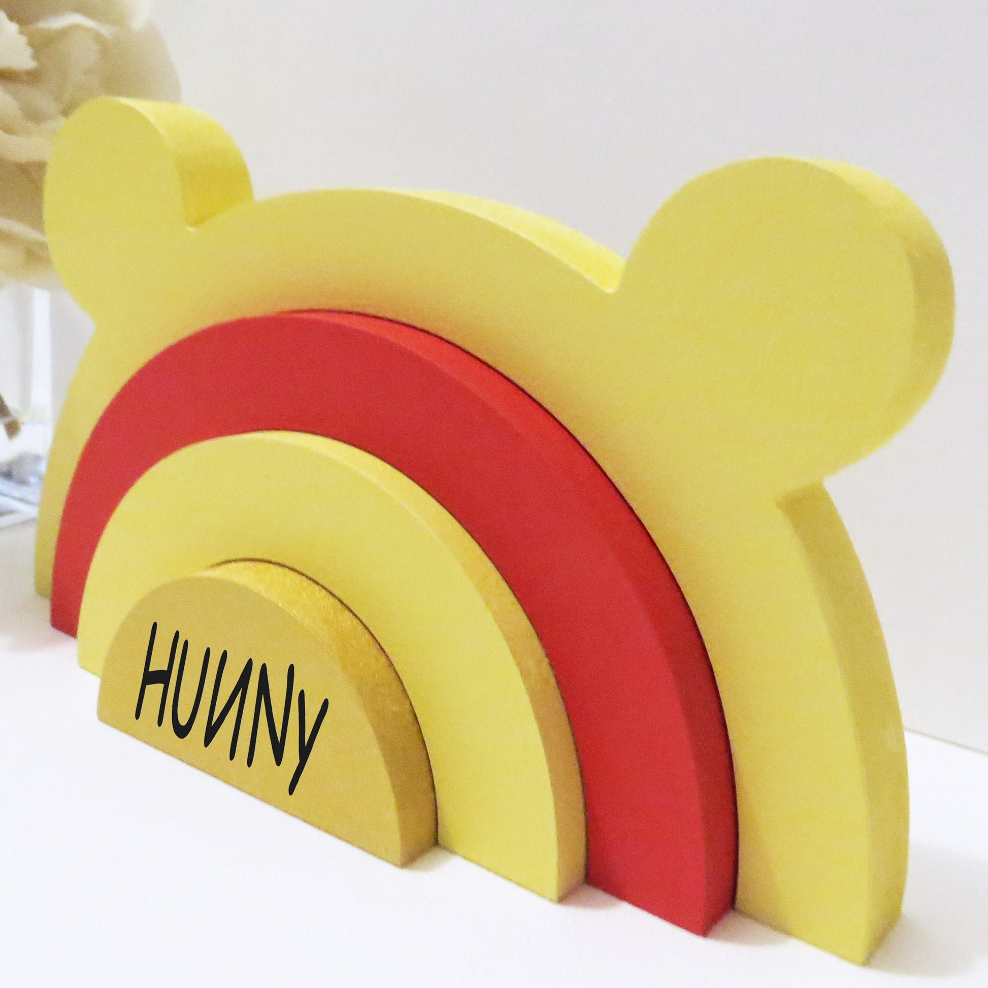 Bear shaped rainbow stacker painted in Winnie The Pooh colours.
