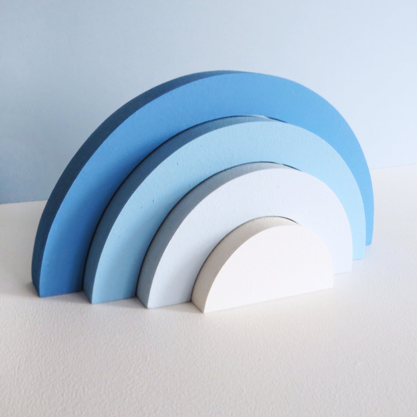 Childrens nursery 4 section rainbow shelf stacker painted in a blue ombre design.