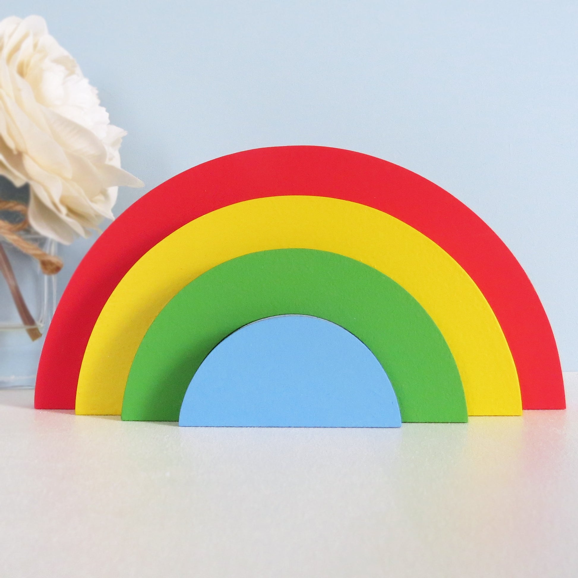 Childrens nursery 4 section rainbow shelf stacker painted in bright colours.