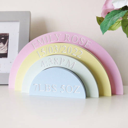 A childrens nurery rainbow shaped shelf stacker painted in pastel colours.