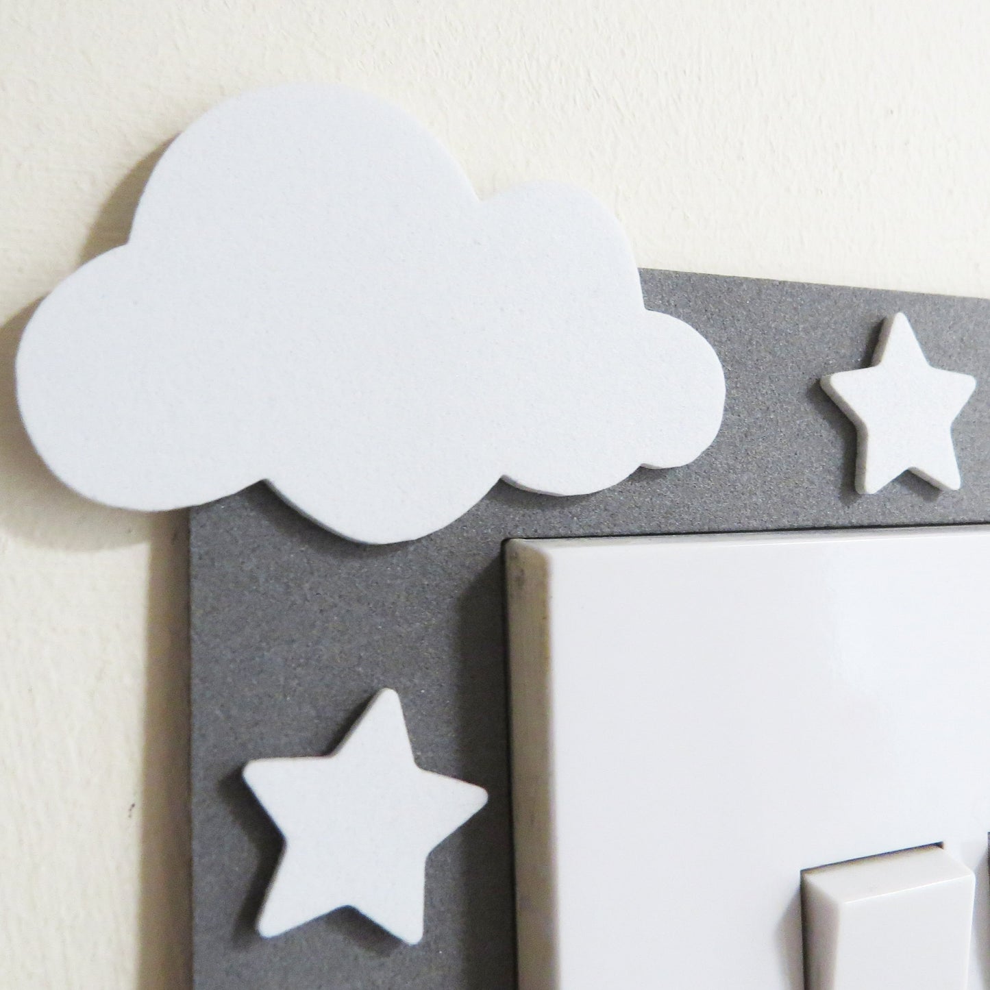 Grey craft foam light switch surround designed with clouds, stars  and a moon.