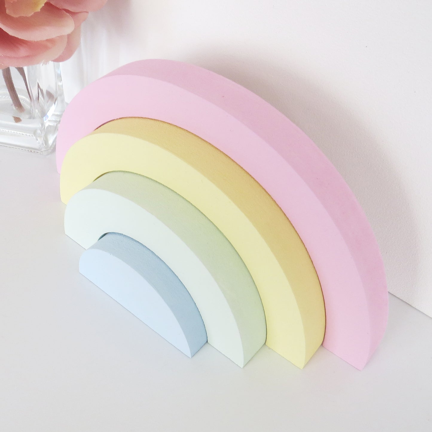 Childrens nursery rainbow shelf stacker painted in pastel colours.